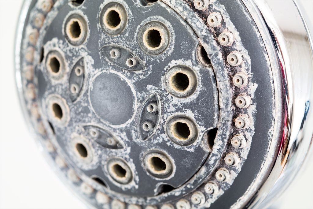Close-up view of mineral buildup on faucet valve stem causing sticking problems